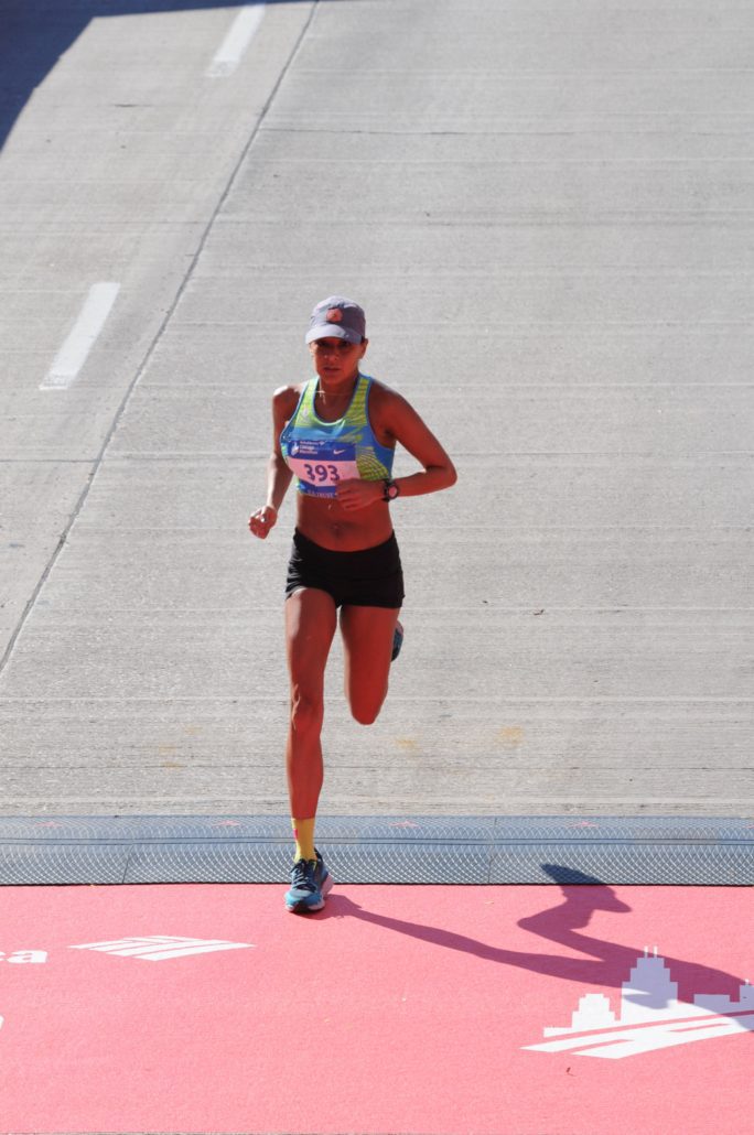 Image of Anita Perez crossing the Chicago Marathon finish line.