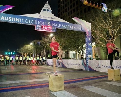 Image of two Camp Gladiator trainers warming up participants of the 2019 Austin Marathon. CG returns as the 2020 Austin Marathon's Official Community Fitness Partner.