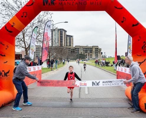 Young runner crosses the finish line of the 2019 Manzano Mile presented by Dole Packaged Foods.