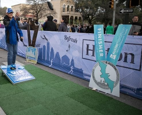 Image of participant playing bag toss at the 2019 Austin Marathon Hilton VIP Experience. Hilton is the 2020 Austin Marathon's Preferred Hotel Partner.