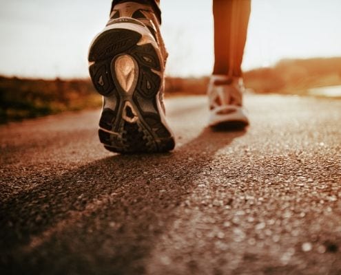 Image of runner walking on concrete on their life-changing journey.