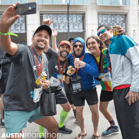 Group of friends take a selfie at the 2019 Austin Marathon finish line, capping off an unforgettable Austin Marathon weekend.