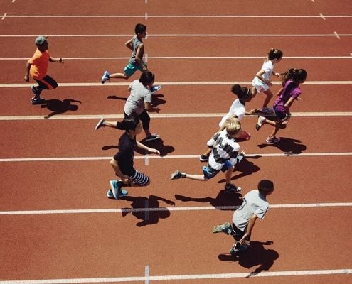 Image of children running on the track during a Marathon Kids event. Marathon Kids is the beneficiary of the Manzano Mile presented by Dole Packaged Foods.