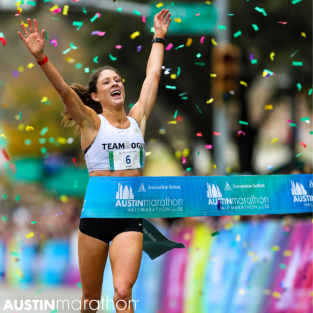 Sarah Jackson, 2020 Austin Marathon female champ, crossing the finish line with her arms raised joyously in the air. Running is a great way to reduce your stress.