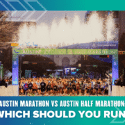 A large group of runners lines up at the starting line of the Austin Marathon & Austin Half Marathon under an archway with fireworks overhead. Text below asks, "Austin Marathon vs Austin Half Marathon: Which should you run?". Austin Marathon Half Marathon & 5K