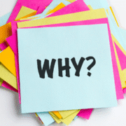 A stack of colorful paper squares with a light blue sheet on top displaying the word "WHY?" in bold, black letters—perfect inspiration for any beginner runner crafting their personal motivation or assembling a runner checklist. Austin Marathon Half Marathon & 5K