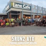 A large group of runners poses outside a building labeled “Lane Cafe” at dusk. Below them, a banner reads “5RUN2 Austin FREE GROUP RUN” on a map-themed background with small icons, celebrating the spirit of a group run. Austin Marathon Half Marathon & 5K