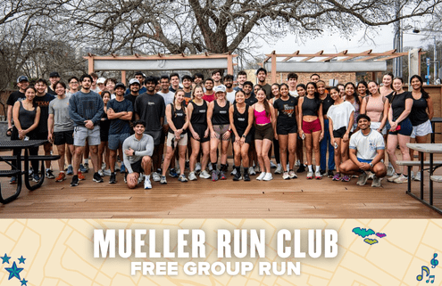 A large, diverse group of people in athletic wear pose and smile outdoors for a group photo. Text at the bottom reads: "Mueller Run Club - Free Group Run." Trees and wooden benches frame this lively free run gathering. Austin Marathon Half Marathon & 5K