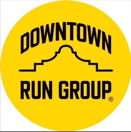 Yellow circle logo with "DOWNTOWN RUN GROUP" in bold black letters. "DOWNTOWN" arches above a stylized building outline, with "RUN GROUP" below—perfect for Austin running groups and free group runs. Austin Marathon Half Marathon & 5K