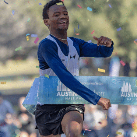 A runner joyfully crosses the finish line at the Austin Half Marathon on race day, his mental preparation and visualization techniques shining as colorful confetti falls around him. Austin Marathon Half Marathon & 5K