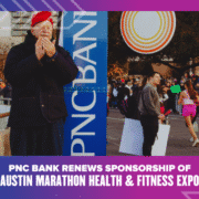 A man in a red beret claps near a PNC Bank sign as runners and spectators gather at the Austin Marathon. Text below reads, "PNC Bank Renews Sponsorship of Austin Marathon Health & Fitness Expo. Austin Marathon Half Marathon & 5K
