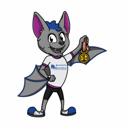 A cheerful cartoon bat wearing a white T-shirt and sneakers stands smiling, holding up a gold medal. The shirt features a blue "Autism Marathon" logo and running rules for how to change race distance. Austin Marathon Half Marathon & 5K