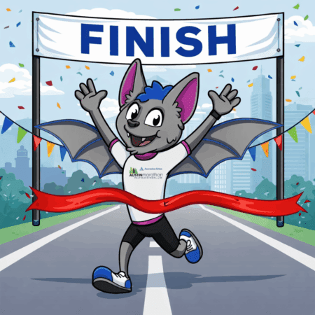 A cheerful cartoon bat in running gear crosses a red finish line ribbon under a "FINISH" banner at a marathon, celebrating completing the race distance as confetti falls and a city skyline shines in the background. Austin Marathon Half Marathon & 5K