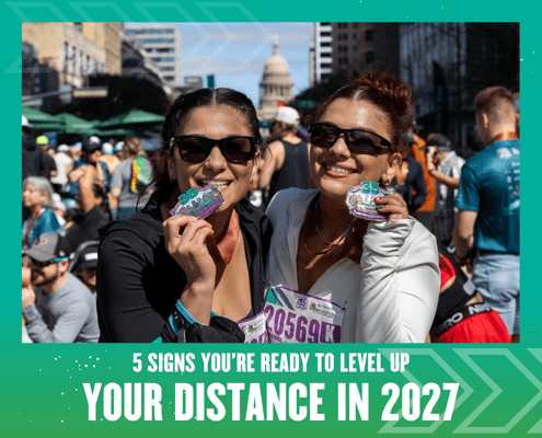 Two women in athletic clothes smile and hold up medals at a busy outdoor race event. The text reads: "5 signs you’re ready to level up your distance for 2027." The Texas Capitol building rises in the background. Austin Marathon Half Marathon & 5K