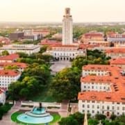 Aerial view of the University of Texas at Austin campus, featuring the Main Building tower and red-roofed buildings, with green lawns and a fountain surrounded by trees—near where the Austin Marathon course winds through vibrant Austin neighborhoods. Austin Marathon Half Marathon & 5K