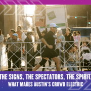 A runner passes cheering spectators behind a barricade at a city street event; one person holds a sign, and sunlight highlights the energetic crowd. Text below reads: "THE SPIRIT, THE SPECTATORS, THE ELECTRIC ATMOSPHERE: WHAT MAKES AUSTIN’S CROWD UNIQUE. Austin Marathon Half Marathon & 5K