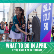 A smiling runner hits a large gong at the race finish area. She wears a medal and race bib, with a crowd and distance markers (26.2, 13.1, 5K) in the background. Text reads: "What to do in April if you want a PR in February. Austin Marathon Half Marathon & 5K