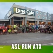 A large group of people pose outside Lane Cafe at dawn or dusk in athletic clothes, representing a Group Run. Text at the bottom reads "ASL RUN ATX." The image features a green and yellow border with arrow graphics. Austin Marathon Half Marathon & 5K