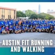 A large group of people in blue shirts pose together outdoors in a parking lot, with buildings and trees in the background. Text at the bottom reads "Austin Fit Running Club and Walking. Austin Marathon Half Marathon & 5K