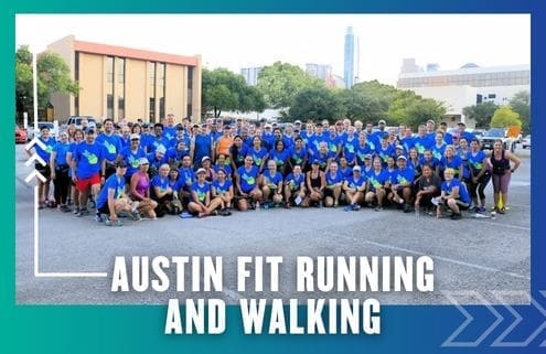 A large group of people in blue shirts pose together outdoors in a parking lot, with buildings and trees in the background. Text at the bottom reads "Austin Fit Running Club and Walking. Austin Marathon Half Marathon & 5K