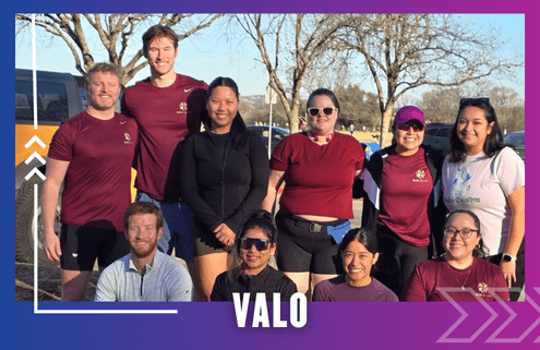 A group of eleven people, some standing and some kneeling, pose outside in athletic wear after a Group Run. The scene is sunny with trees in the background, and the word "VALO" is displayed at the bottom. Austin Marathon Half Marathon & 5K