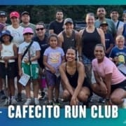 A diverse group of adults and children, smiling and dressed in athletic wear, pose together outdoors for a group photo after a Buda Running Club Group Run. Text at the bottom reads, "CAFECITO RUN CLUB. Austin Marathon Half Marathon & 5K