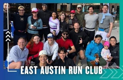 A group of smiling people, dressed in athletic wear, pose together outdoors for a photo. The text at the bottom reads "East Austin Run Club," highlighting a vibrant community running club on a blue and green background with white arrow graphics. Austin Marathon Half Marathon & 5K
