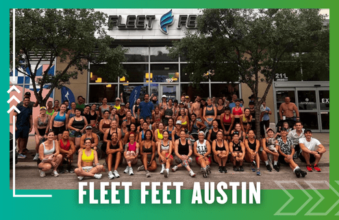A large, diverse group of people in athletic wear pose and smile outside the Fleet Feet Austin store after a Friday Morning Run, surrounded by trees, with the store’s logo visible above the entrance. Austin Marathon Half Marathon & 5K