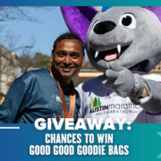 A smiling man wearing a medal stands next to a person in a large purple bat mascot costume at an outdoor event. Text reads: "GIVEAWAY: CHANCES TO WIN GOOD GOOD GOODIE BAGS." Perfect template for your next exciting giveaway!. Austin Marathon Half Marathon & 5K