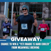 A smiling runner in sunglasses and a beanie flashes peace signs during a race, with others in the background. Enter the Giveaway below for your chance to win a Yeti Roadie 15 Hard Cooler from Meanwhile Brewing!. Austin Marathon Half Marathon & 5K