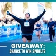 A runner with arms raised triumphantly crosses the finish line at the Maudie's Moonlight Run, surrounded by other racers. Text reads: “GIVEAWAY: CHANCE TO WIN ENTRIES.” Blue banners and spectators are visible in the background. Austin Marathon Half Marathon & 5K