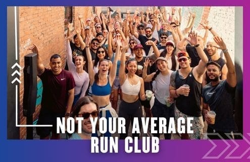 A large, diverse group of smiling people in athletic wear poses cheerfully for a photo in an alley, some raising their hands. Text reads: “Not Your Average Run Club.” Celebrate every Group Run with the Buda Running Club!. Austin Marathon Half Marathon & 5K