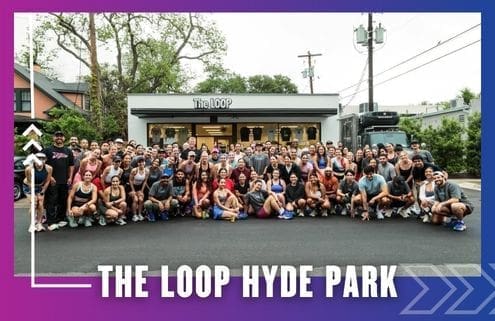 A large group of people, including members of Buda Running Club, pose and smile for a photo in front of The LOOP Hyde Park storefront, with trees and a food truck in the background on a sunny day. Text at the bottom reads "THE LOOP HYDE PARK. Austin Marathon Half Marathon & 5K